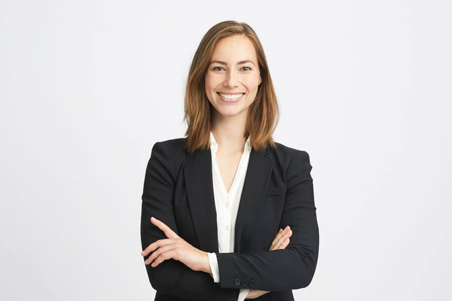 Female wearing a smart jacket facing camera and smiling.